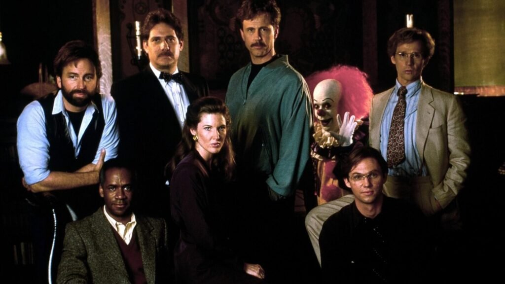 Harry Anderson (centre) as the adult Richie Tozier, posed with the adult Losers Club and Tim Curry's Pennywise — Stephen King's It (1990)