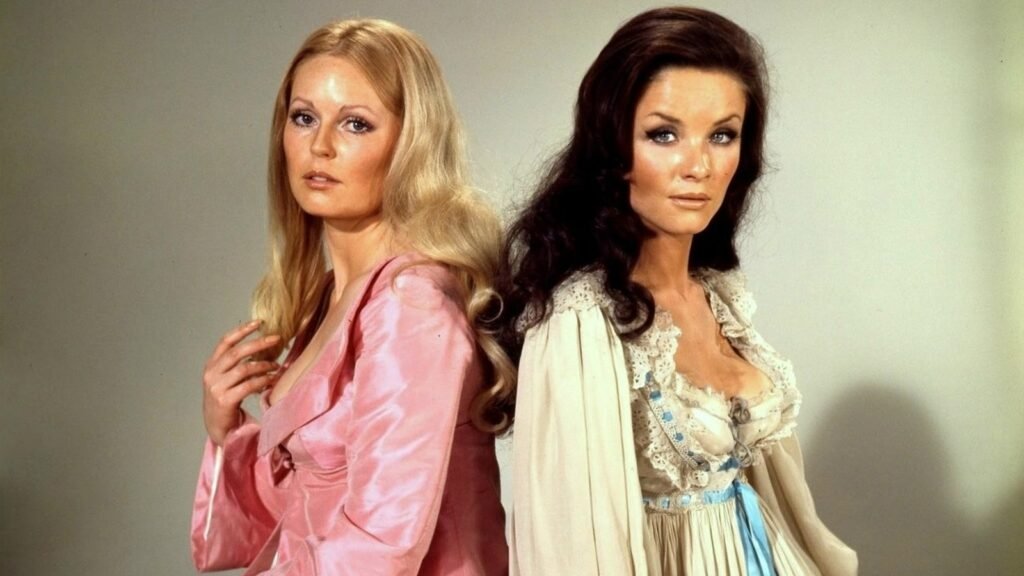 Veronica Carlson as Elizabeth Heiss and Kate O'Mara as Alys, back to back, in The Horror of Frankenstein (1970)